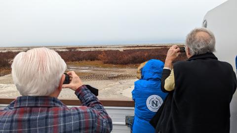 adventurers looking at polar bear from afar